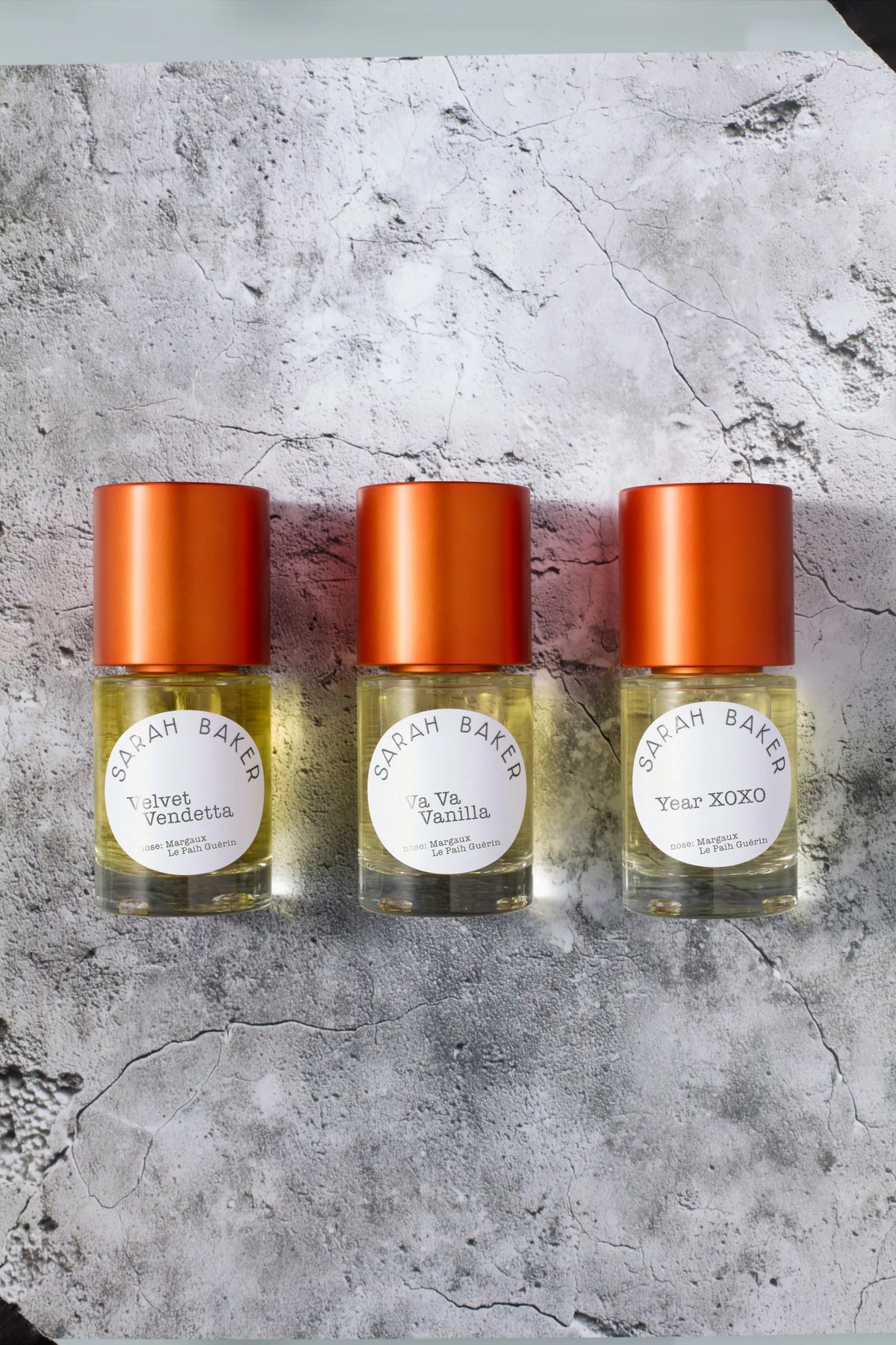Velvet Vendetta, Va Va Vanilla and Year XOXO perfume bottles on a grey background.