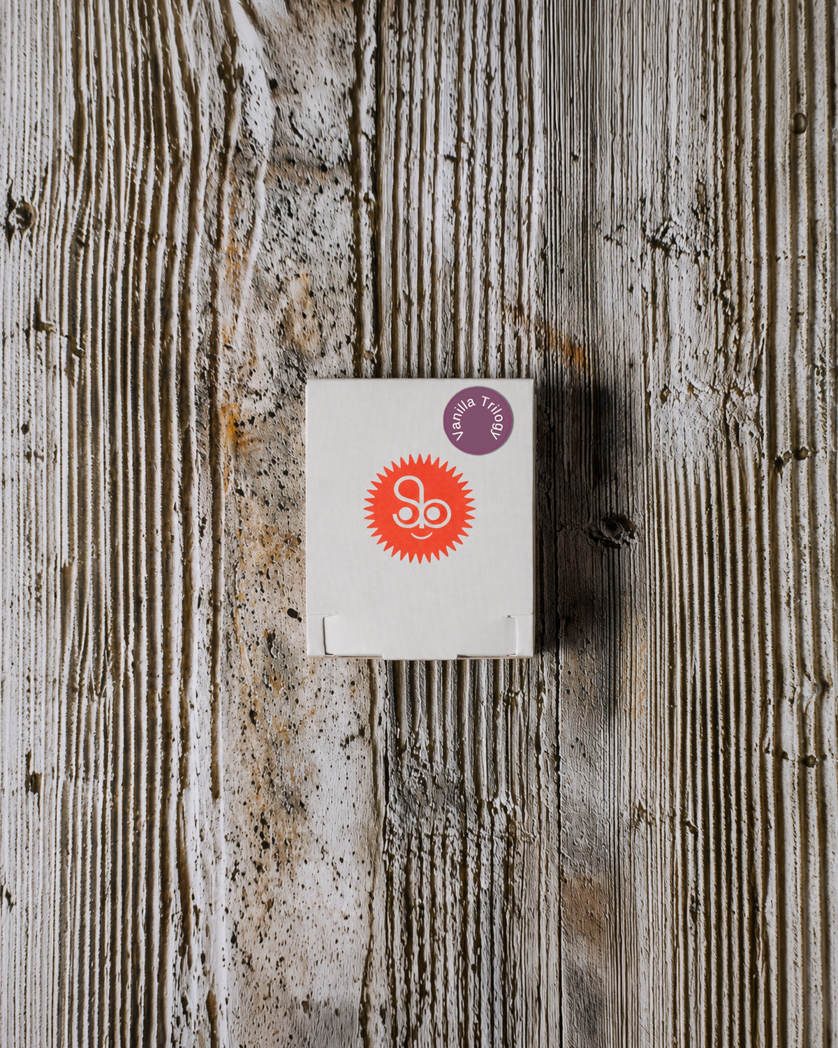 Mini Vanilla Trilogy discovery set box on a weathered wood background.
